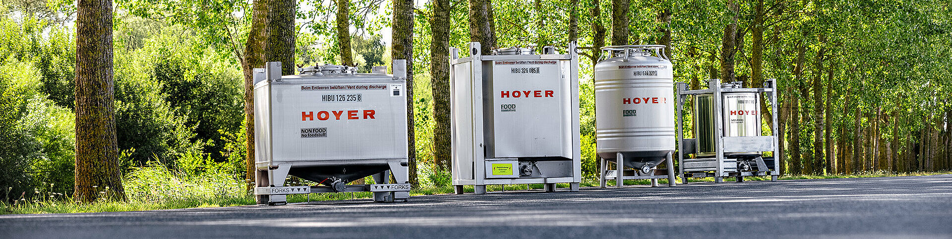 HOYER IBC on a street in front of a wood