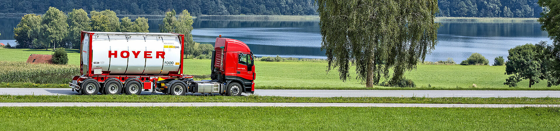 HOYER Lkw mit Lebensmittel-Tankcontainer auf einer Landstraße 