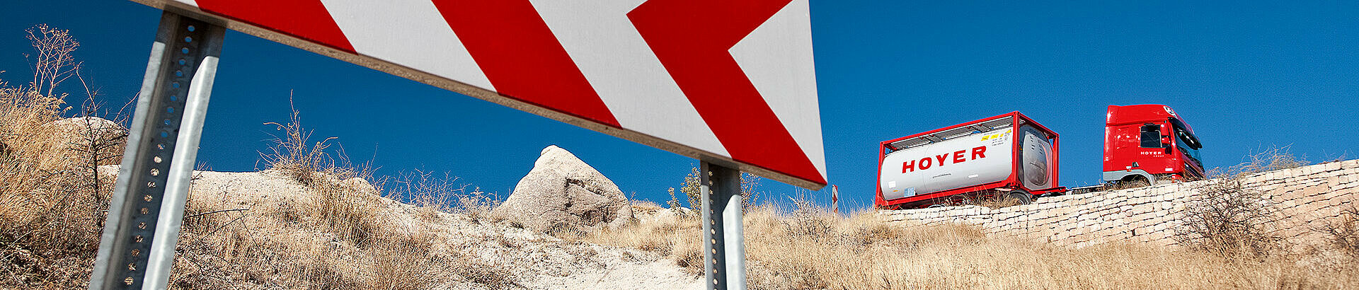 Safety HOYER truck in the desert next to a road sign