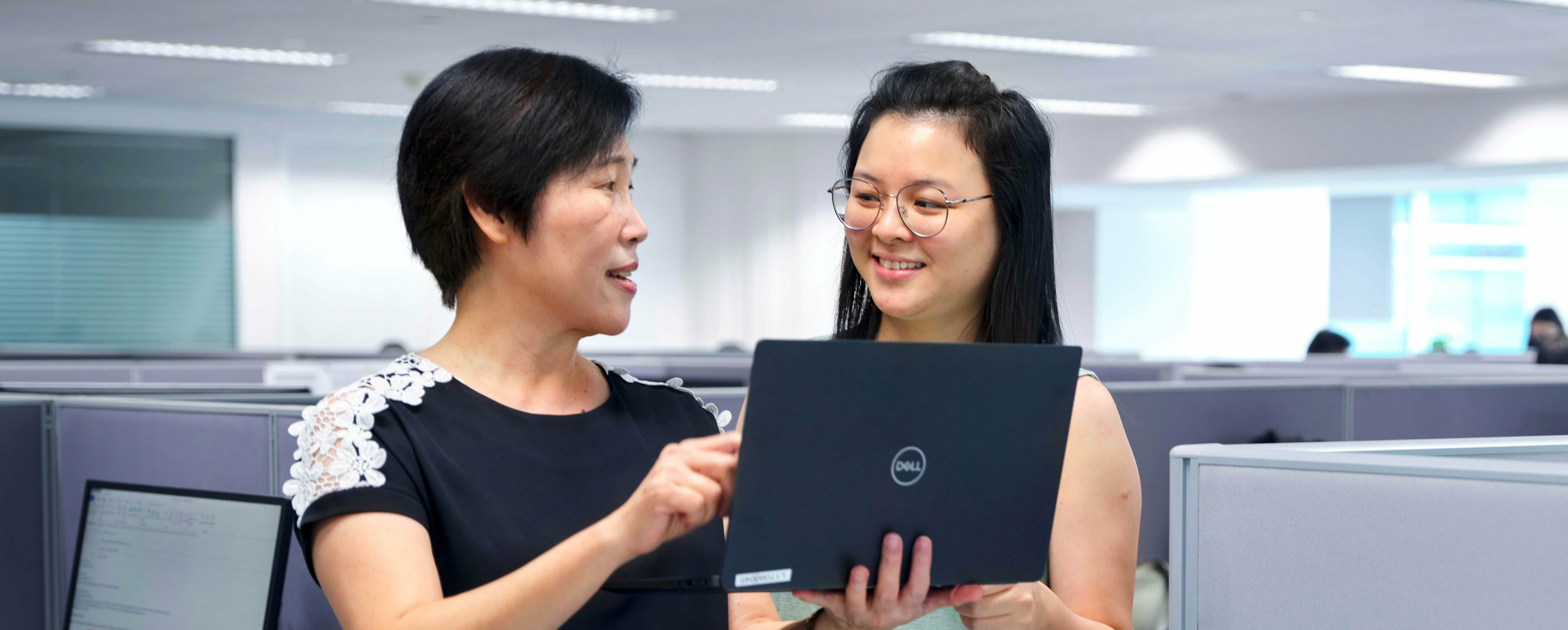 Office workers hold laptop in hand and plan flexitank logistics