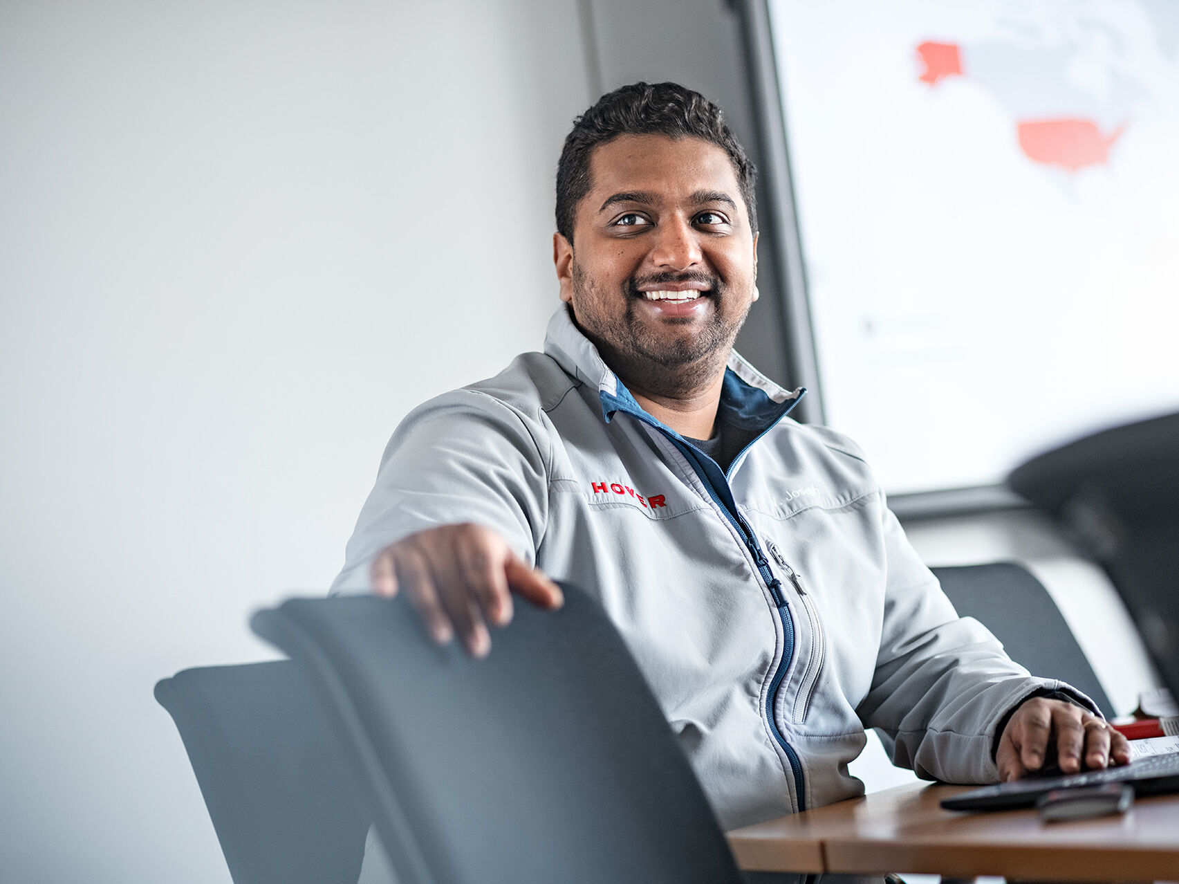 HOYER employee sitting at a table and wearing a HOYER jacket