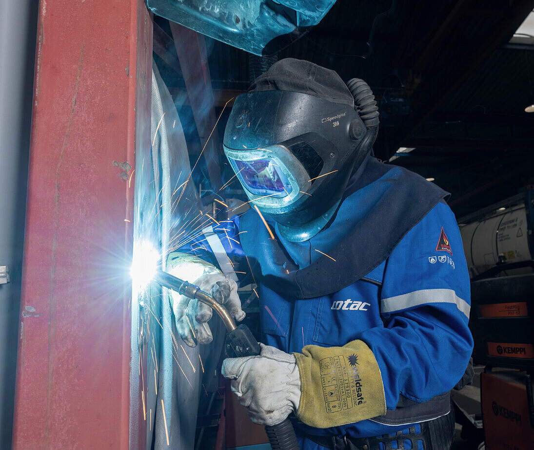 HOYER employee welding an IBC