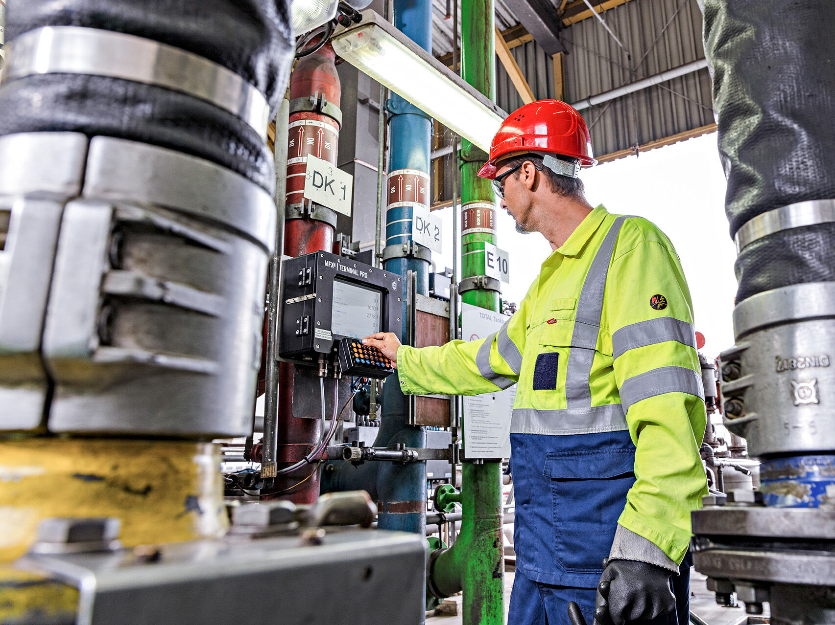 Experts HOYER employee in a warning jacket at a machine