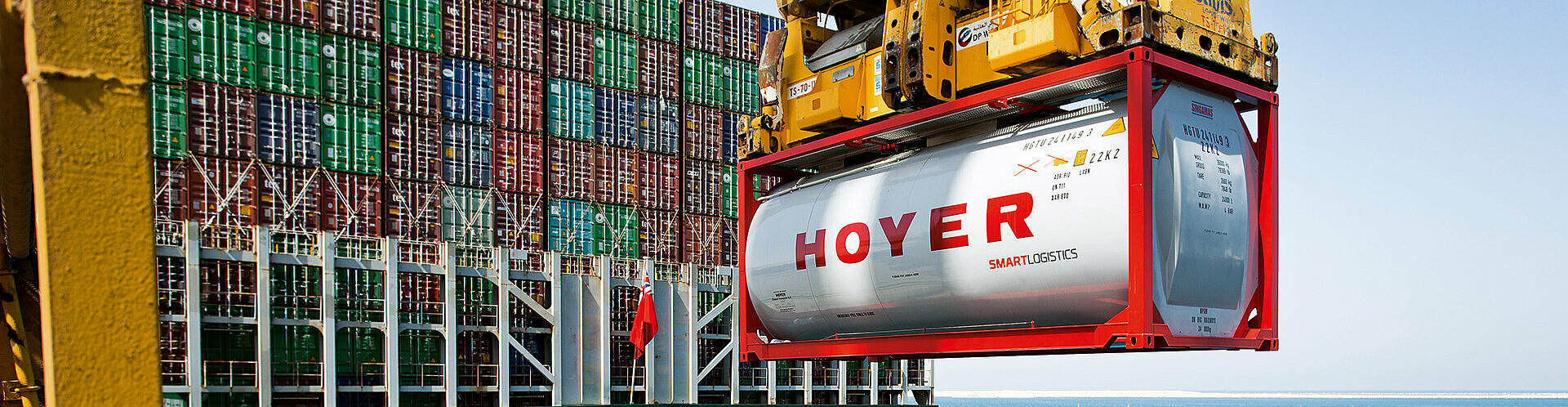 HOYER container smart logistics on a crane at the harbour, ship in the background