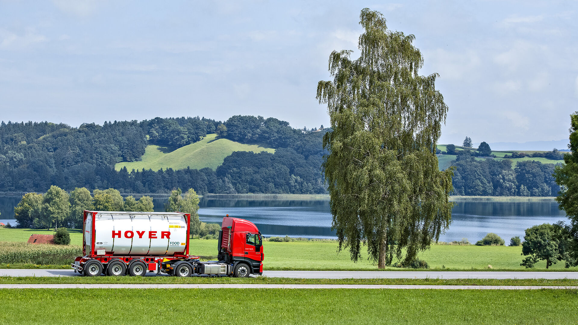 HOYER Lkw auf einer Landstraße mit Lebensmittel-Tankcontainer