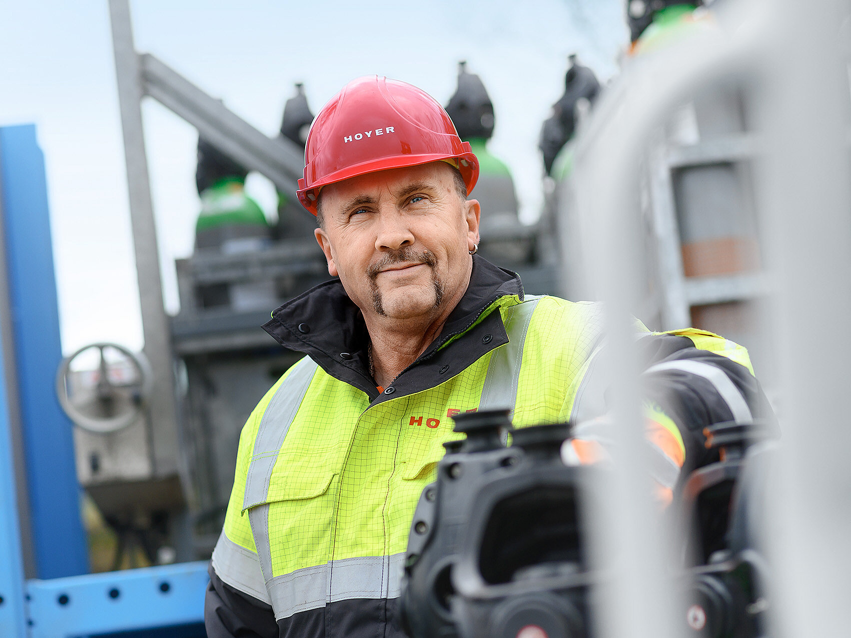 Gas logistics HOYER employee with HOYER jacket and helmet