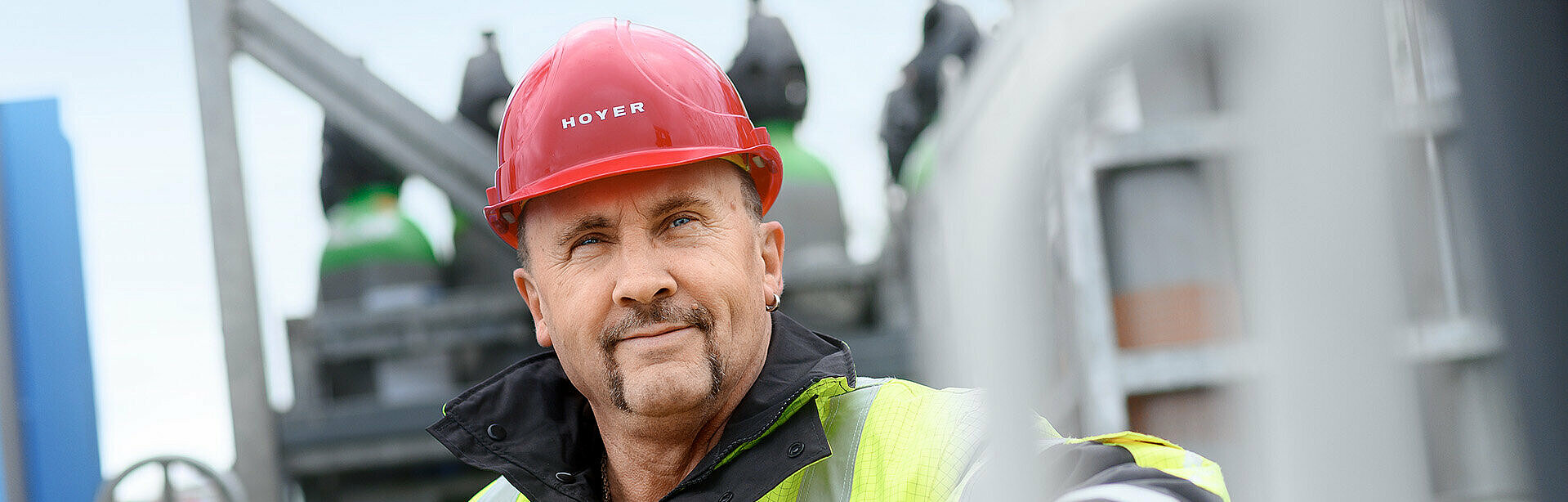 Gas logistics HOYER employee with HOYER jacket and helmet