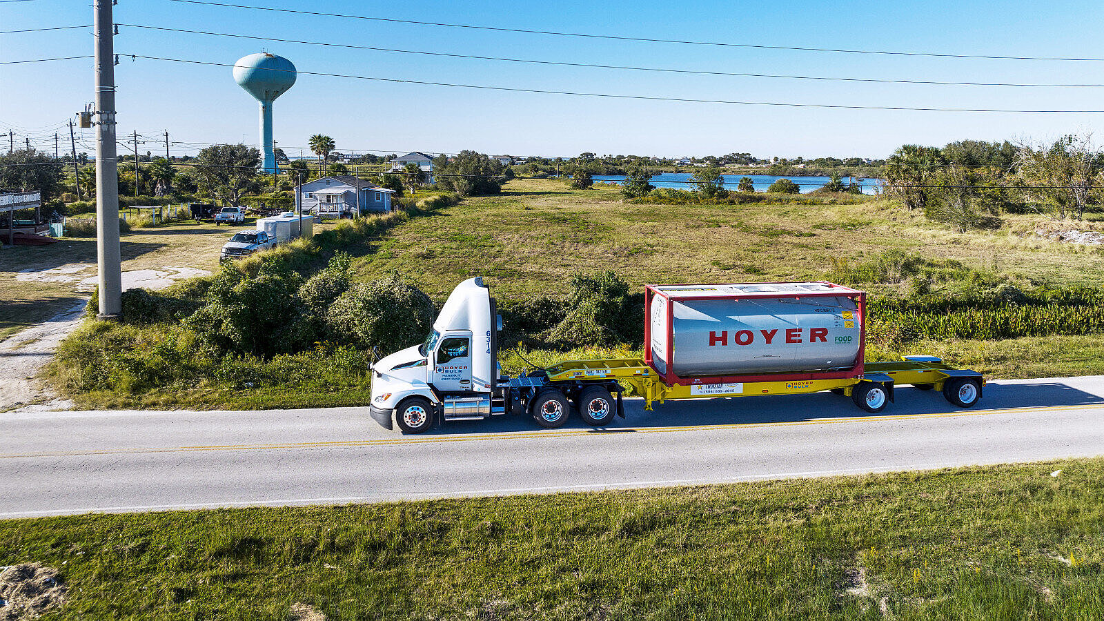 Foodstuff Logistics HOYER Lkw mit Lebensmittel-Tankcontainer auf einer Landstraße