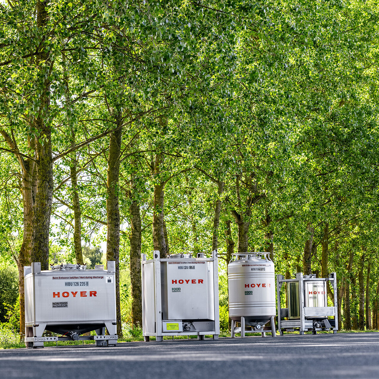 HOYER IBC on a street in front of a wood