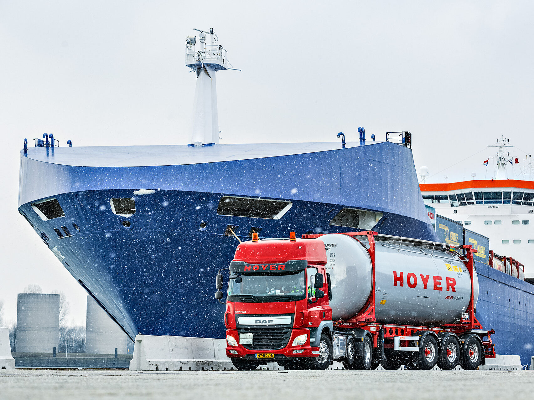 HOYER truck with chemical tank container in front of a ship