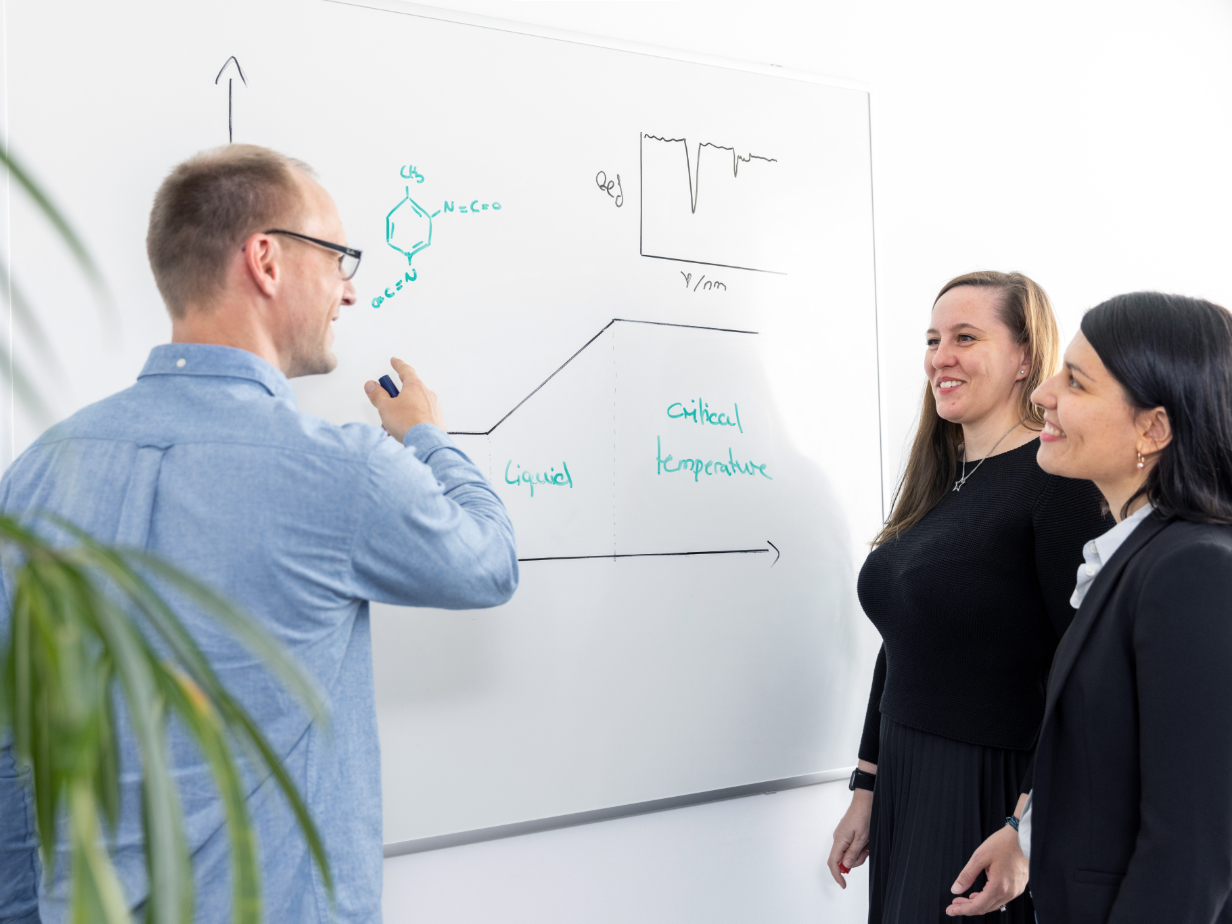 HOYER Group Commercial Chemists stand in front of drawing on a whiteboard