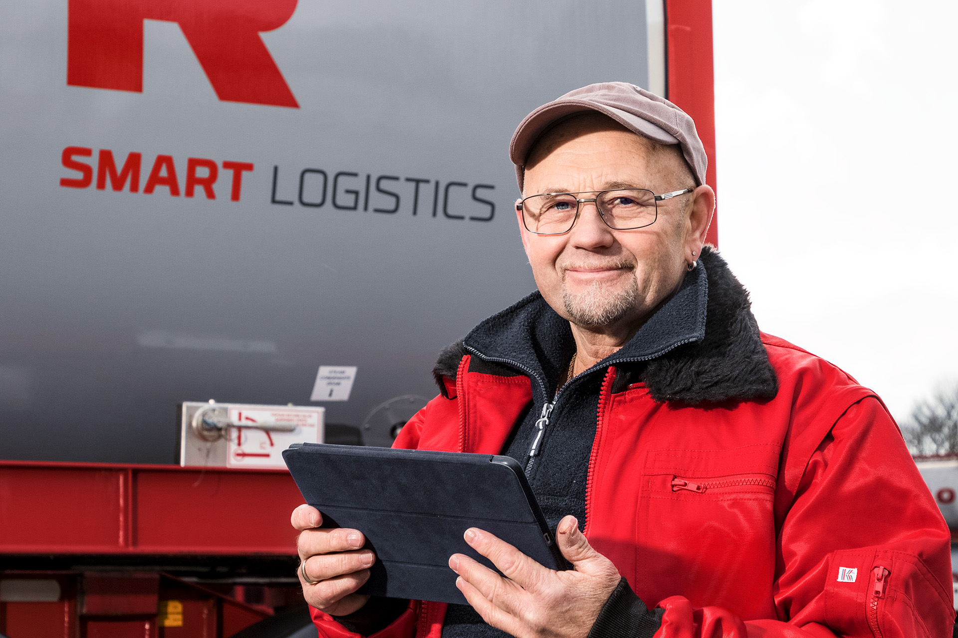 HOYER Mitarbeiter mit Tablet vor einem Smart logistics Tankcontainer