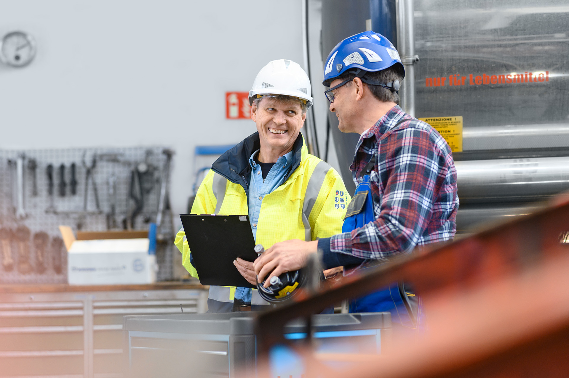 two employees look at each other and hold a document