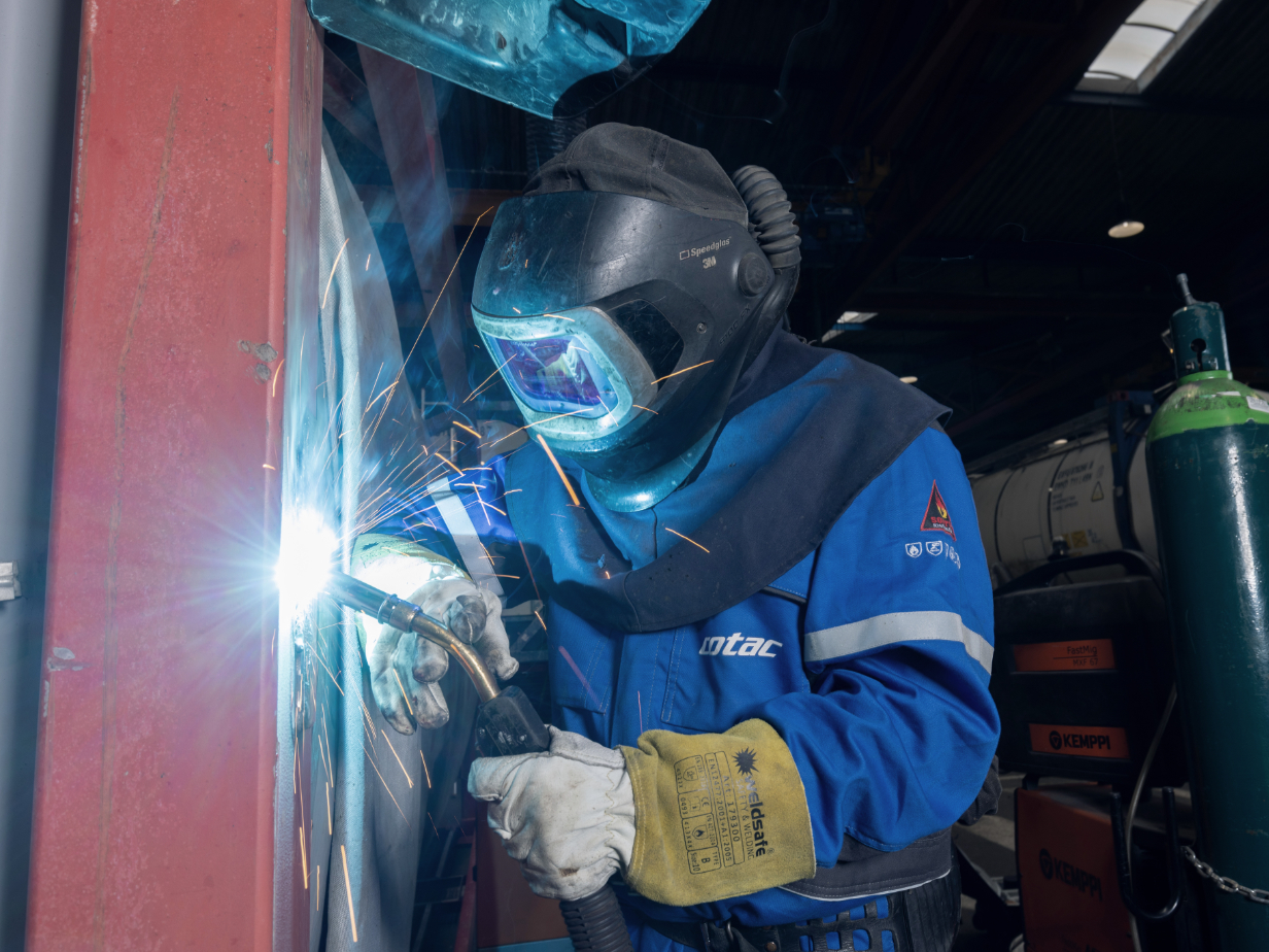 HOYER employee welding an IBC