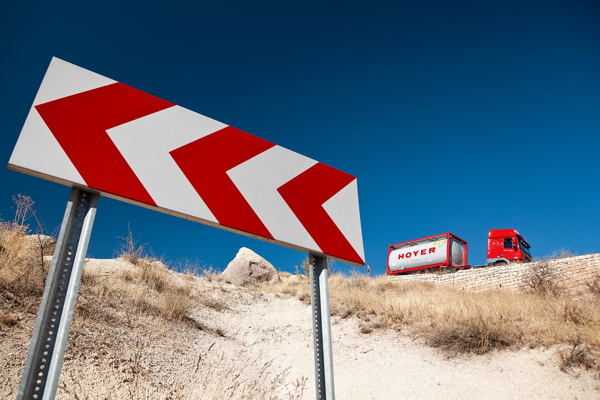 Schild und HOYER Lkw mit Chemie-Tankcontainer im Hintergrund 