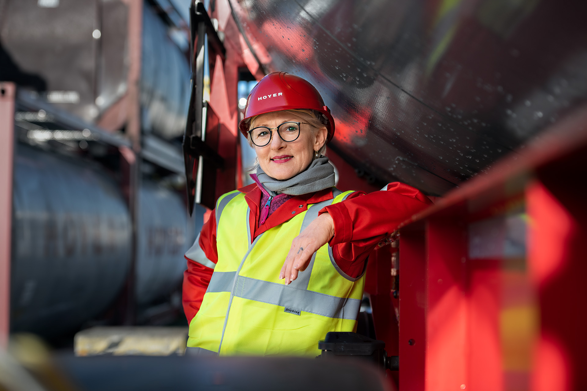 HOYER Fahrerin lehnt an einem Tankcontainer